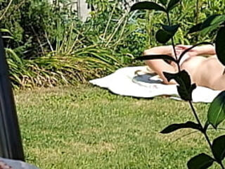 I spy on my stepmother, she is sunbathing naked in the yard