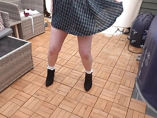 Naughty schoolgirl outdoors in the yard stripping off in high heels